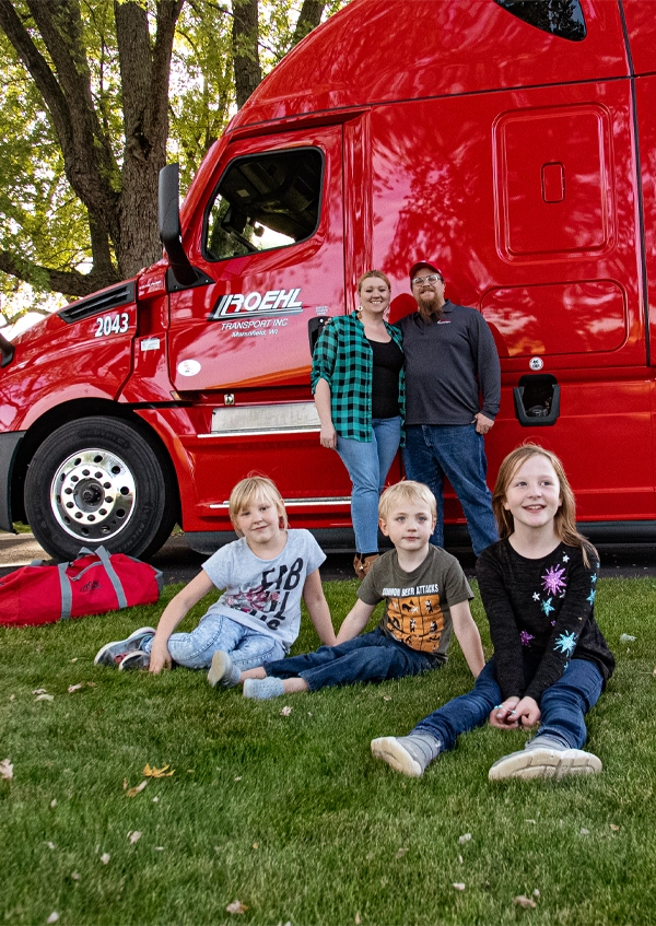 Family at home in front of Roehl truck